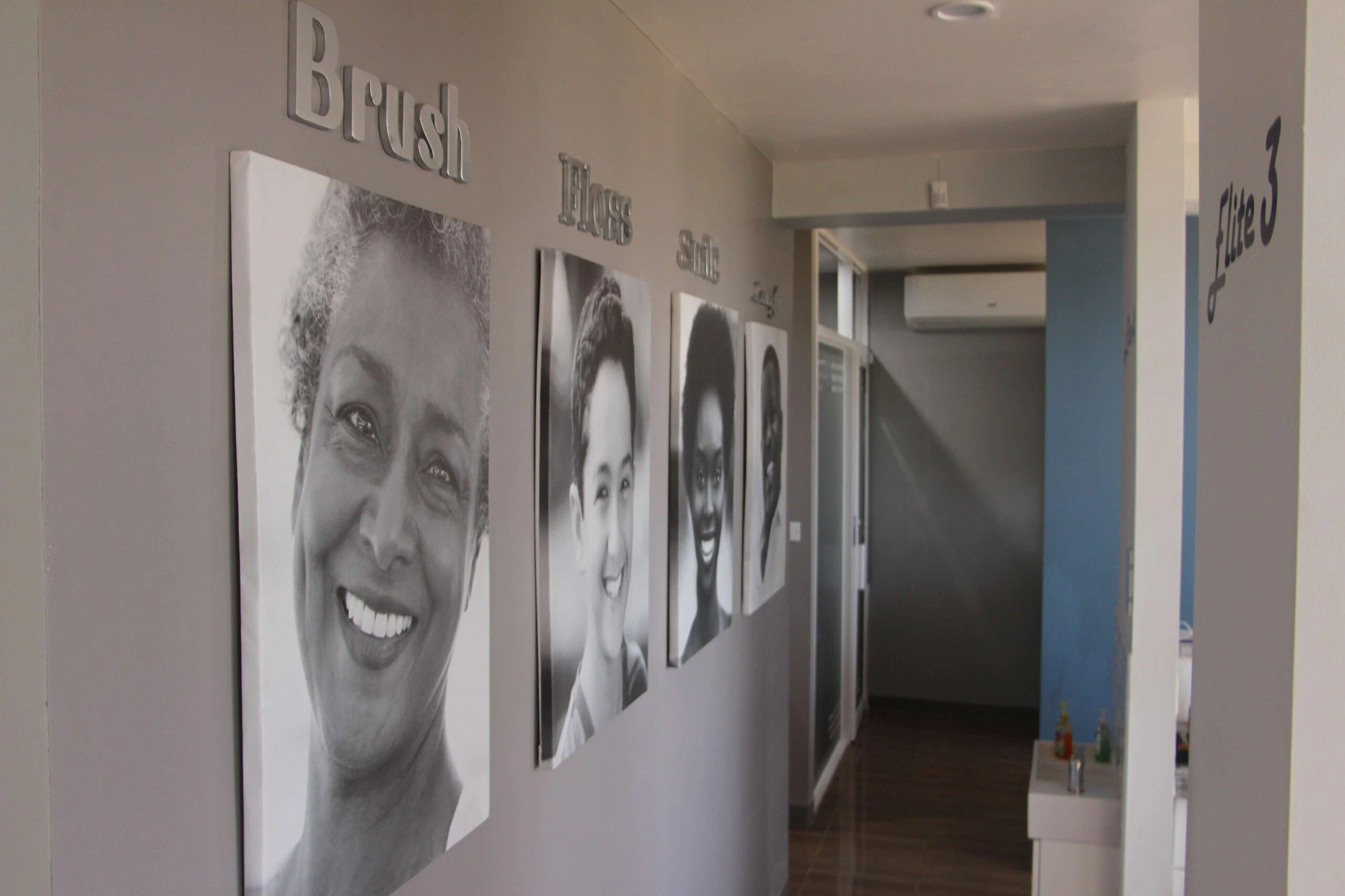 The Elite Smiles hallway decorated with smiling portraits