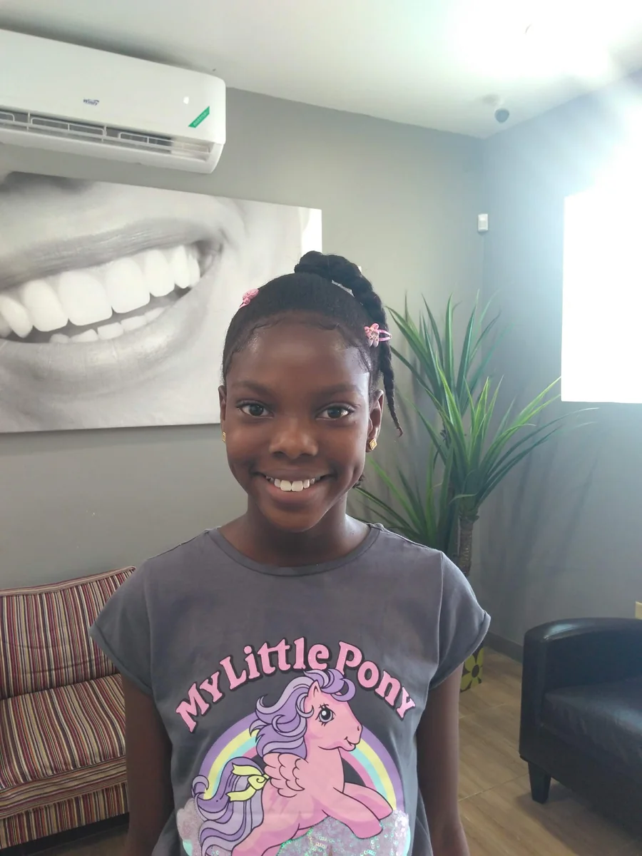 A young patient smiling in the Elite Smiles waiting area