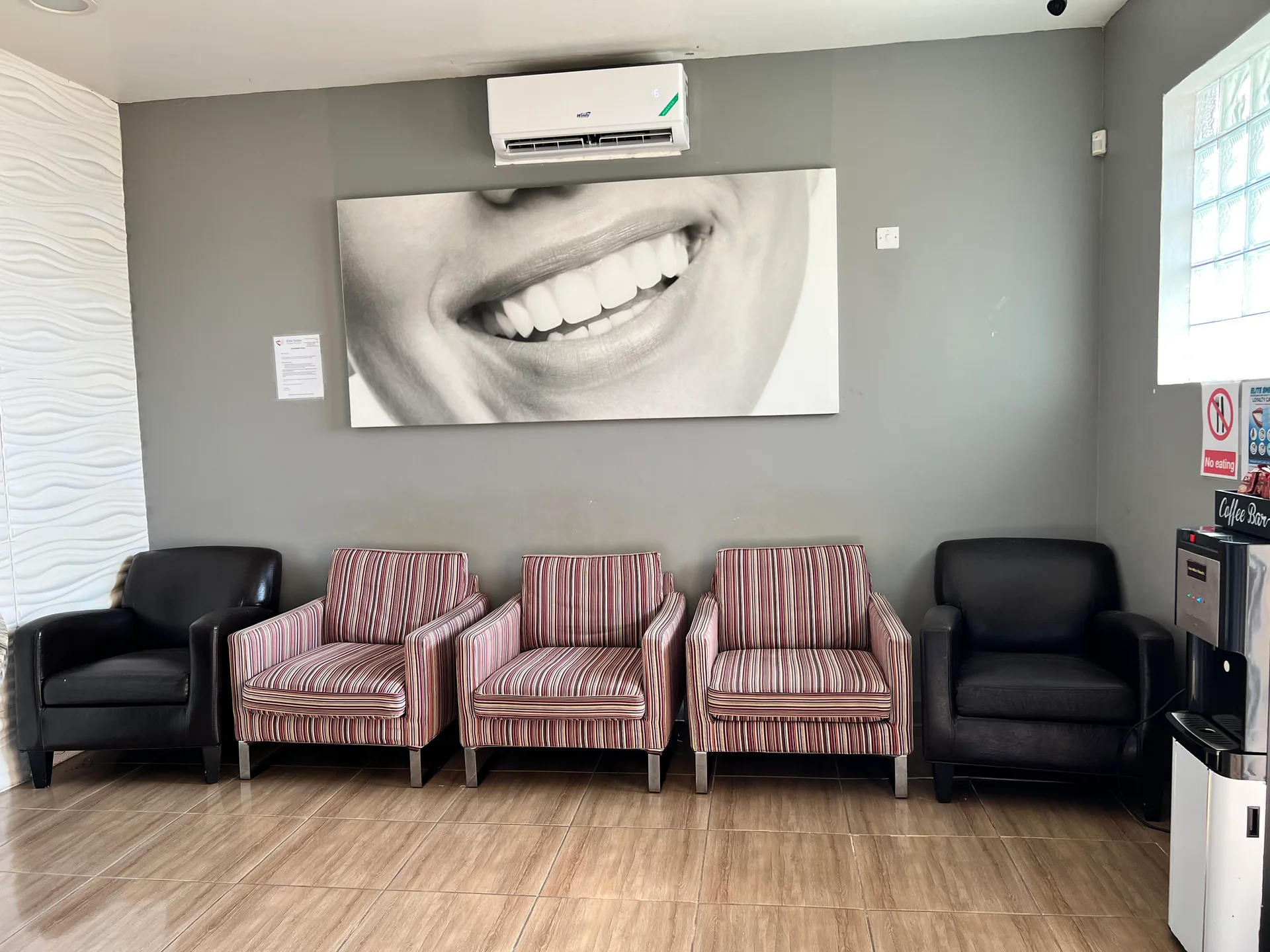 The front waiting area at Elite Smiles with comfortable seating and smile artwork
